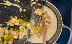 Aggiungi gamberetti e fiori di zucca